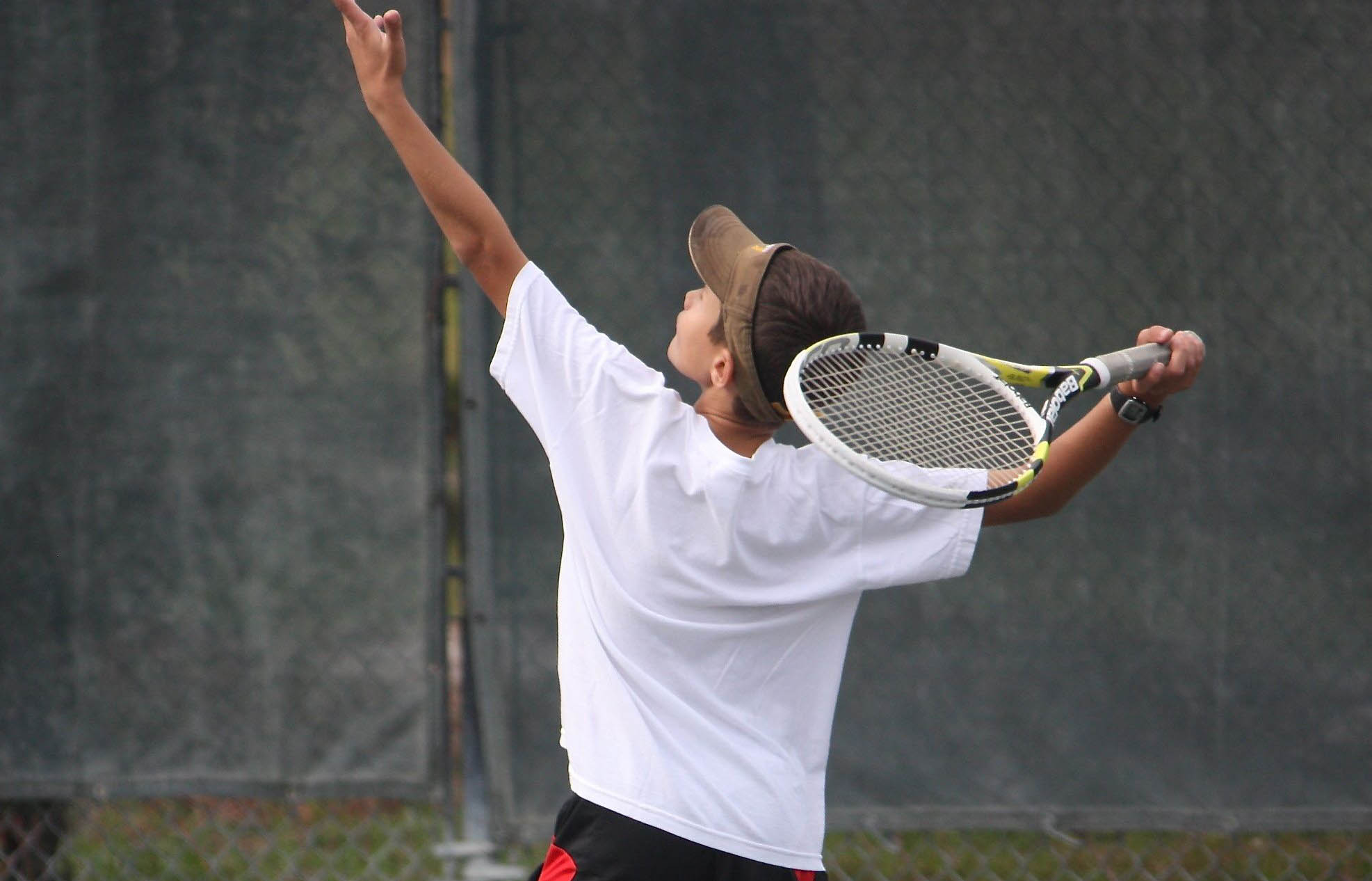 coach teaching junior tennis student